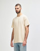 A lightweight, cream-coloured adult t-shirt displayed on a model, featuring a relaxed fit and simple design.