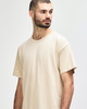 A light beige Gildan Softstyle adult T-shirt displayed on a model, featuring a relaxed fit and round neckline.