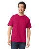 A man wearing a bright pink Gildan Softstyle adult T-shirt, paired with dark jeans. The shirt has a logo.