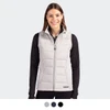 A woman wearing a light grey puffer vest with a zip front. The vest has a logo and is styled with a black top.