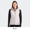 A woman is wearing a light grey, sleeveless hybrid vest with a zip front, featuring a branding logo.