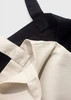 A black and cream canvas tote bag with sturdy handles, featuring a logo.