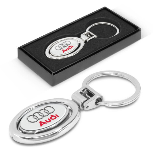 A metal key ring featuring an oval design with the Audi logo, packaged in a sleek black box.