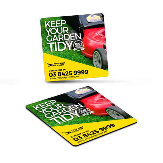 Square fridge magnet featuring a vibrant design with green grass and a red lawnmower, showcasing a logo.