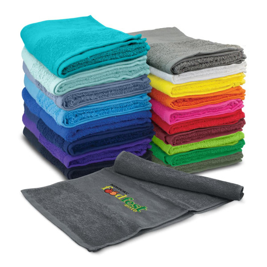 A stack of vibrant gym towels in various colours, including grey, blue, pink, and green, with a towel displaying a logo.