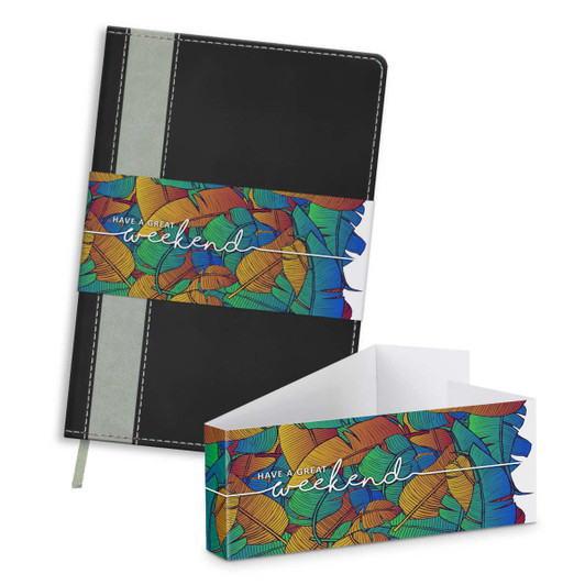 A black notebook with a colourful illustrated band, featuring a hardcover and an elastic closure, lying beside its packaging.