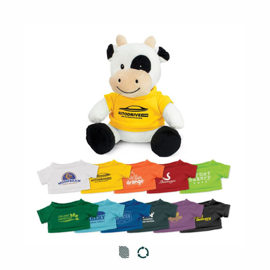 A plush cow toy dressed in a yellow shirt, surrounded by various coloured t-shirts in different sizes.
