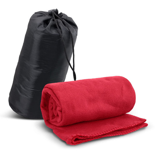 A red fleece blanket rolled up beside a black carry bag. The blanket has a soft texture and is neatly packaged.
