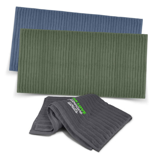Three luxurious towels in blue, green, and grey, featuring textured patterns and a logo.