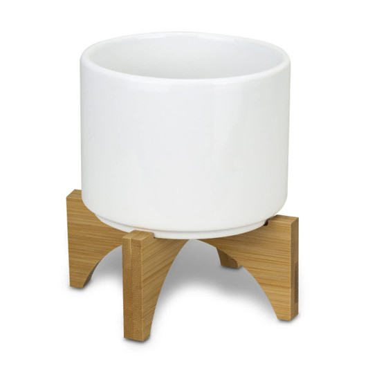 A white ceramic planter with a bamboo base, featuring a modern design and clean lines.