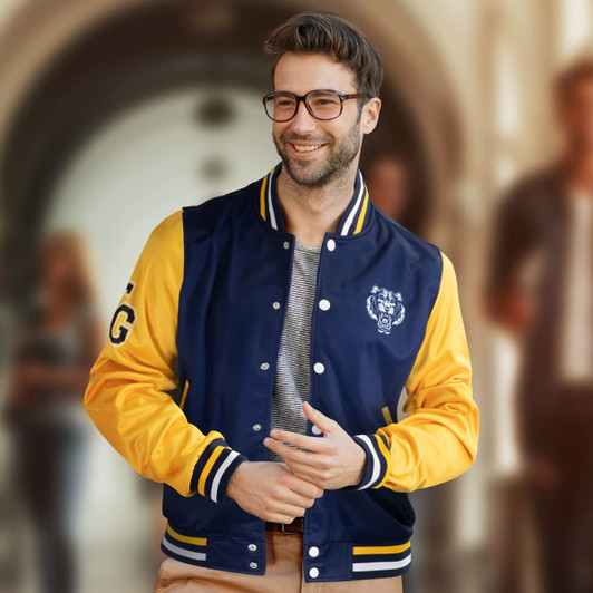 A navy and yellow custom varsity jacket with a logo and striped ribbing, worn by a smiling man.