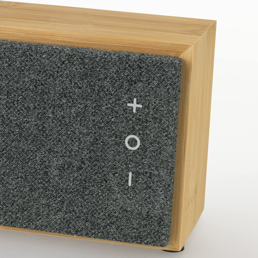 A bamboo Bluetooth speaker with a grey fabric front, featuring control buttons and a logo.