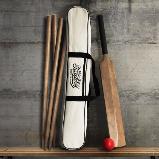 A cricket set featuring a wooden bat, red ball, and four wooden stumps, all contained in a beige carrying bag.