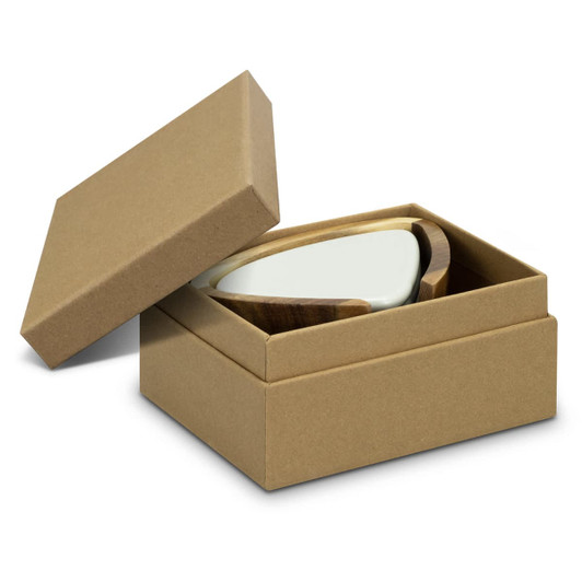 A set of pebble-shaped coasters in a cardboard box, featuring a light green top and a wooden base.