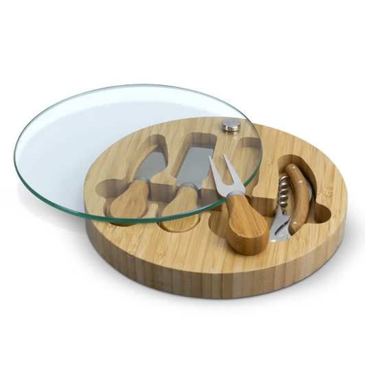 A bamboo cheese board with a glass top, featuring three cheese utensils and a corkscrew.