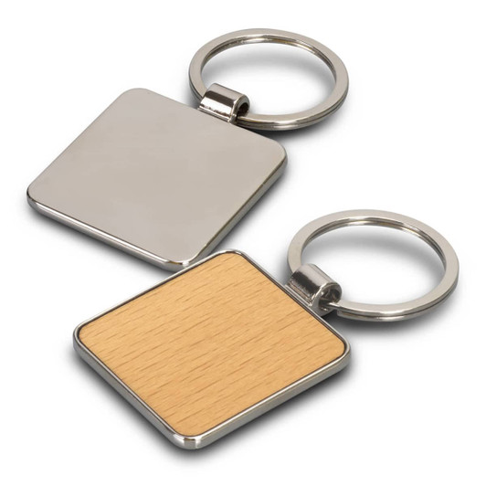 A square key ring featuring a metallic side and a light wooden side, attached to a silver keychain.