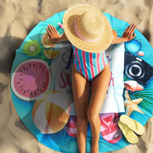 A round beach towel featuring vibrant graphics of watermelons, beach balls, and a camera, in blue and pink tones.