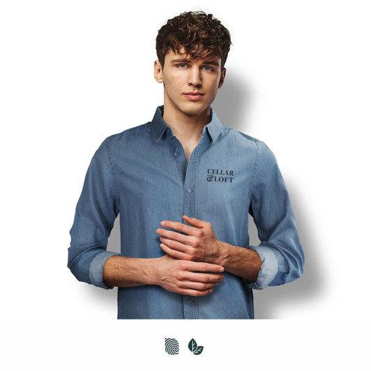 A denim button-up shirt in light blue worn by a young man, featuring a logo on the chest.