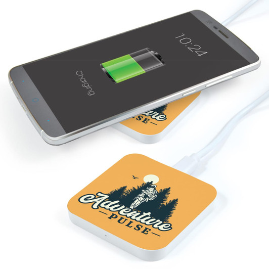 A square orange wireless charger with a design and a smartphone displaying a charging battery icon.