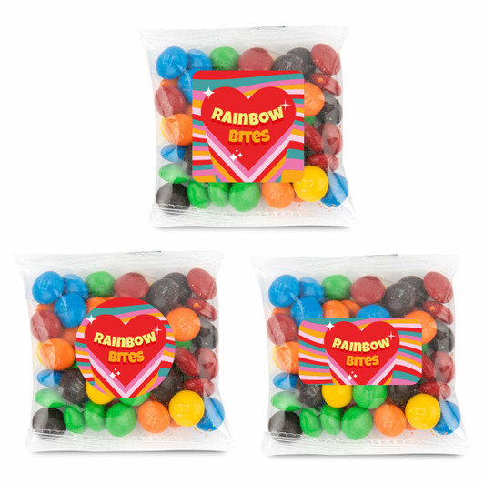 Three clear cello bags containing colorful chocolate-coated candies in various hues, including red, green, blue, and yellow.