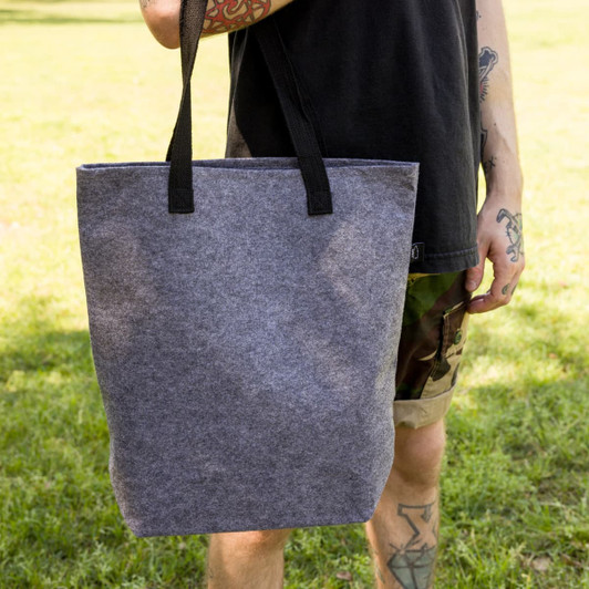 A gray felt tote bag with black handles, featuring a simple design and a spacious interior.