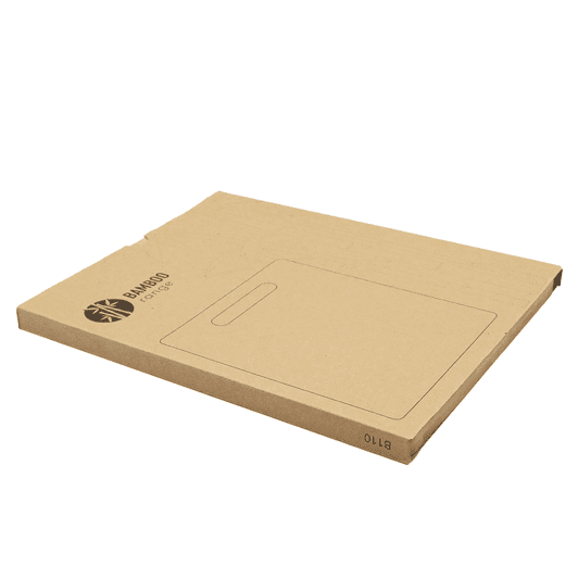 A bamboo chopping board in a cardboard packaging, featuring a handle cut-out and a simple design.