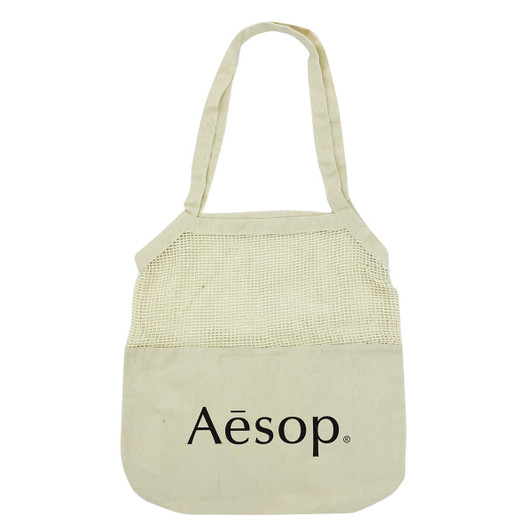 A light beige cotton shopping tote with a mesh top section and a logo on the front.