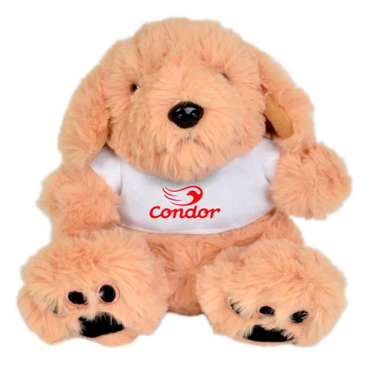 A soft, beige plush puppy sitting upright, featuring a white shirt with a logo. Its paws and ears are dark brown.