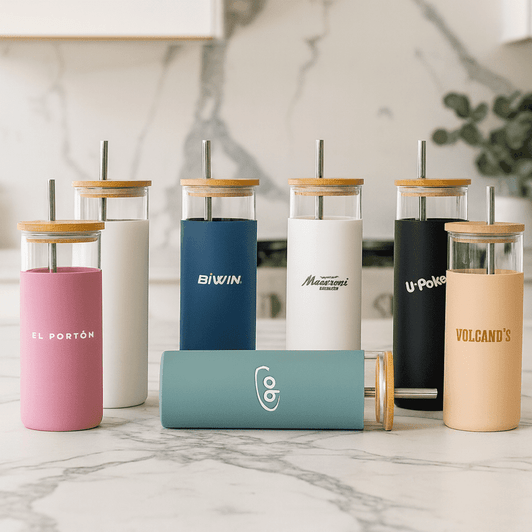 A collection of colourful plastic tumblers with bamboo lids and straws in various shades, featuring different logos.