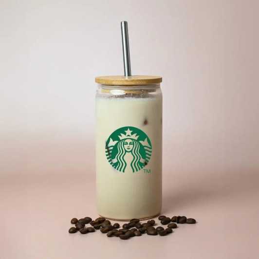 A drink bottle with a wooden lid and metal straw, featuring a logo, surrounded by coffee beans.