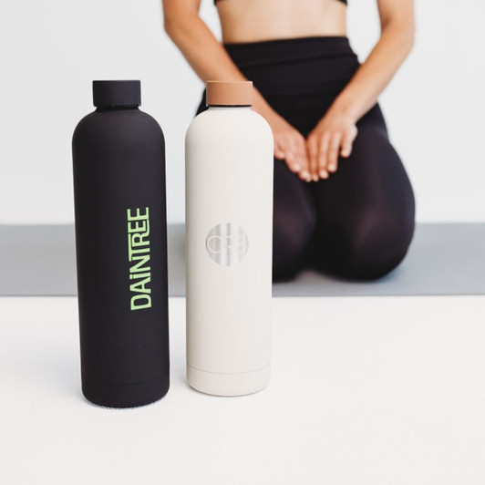 A drink bottle set featuring a black bottle with green text and a cream bottle with a logo, both sleek and modern in design.