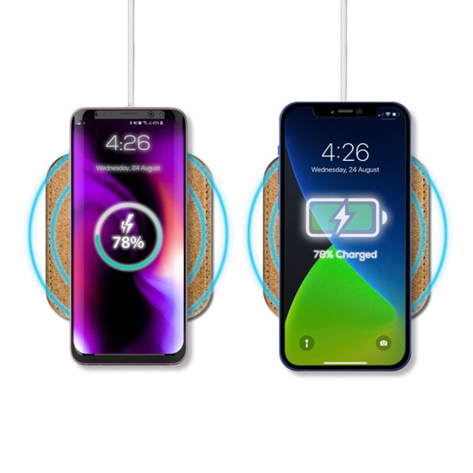 A wireless charger with a cork surface, featuring two smartphones displaying charging status indicators.