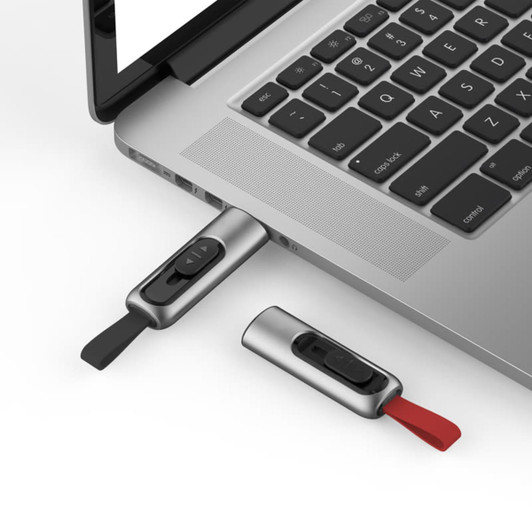 A silver and black Churchill flash drive is plugged into a laptop, with a red one next to it.