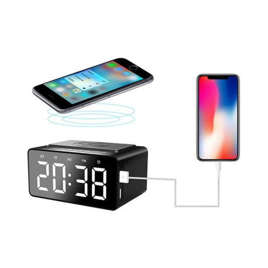 A black wireless charger speaker alarm clock with a digital display, placed near a smartphone.
