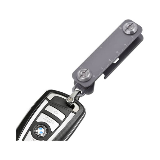 A grey Keyper Case with a keyring attachment, featuring a measuring scale and a sleek design for holding keys.