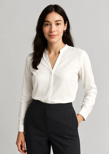 A white long sleeve blouse with a collar, worn by a woman, paired with dark trousers. Branding is present.