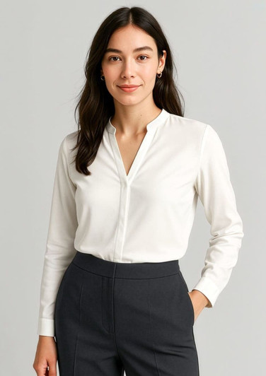 A white long sleeve blouse with a v-neckline and button-up design, paired with dark grey trousers.