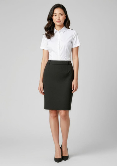 A woman wearing a fitted black skirt and a white collared shirt, standing against a neutral background.
