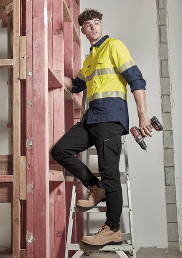 A pair of lightweight black cargo pants worn by a man on a ladder, paired with a yellow and navy shirt and work boots.