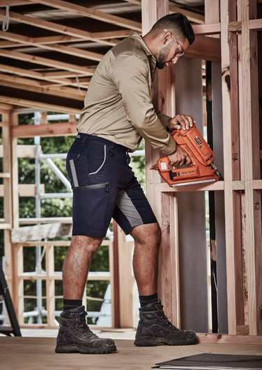 Men's Streetworx Stretch Shorts in navy with grey accents, worn by a man using a nail gun in a construction setting.