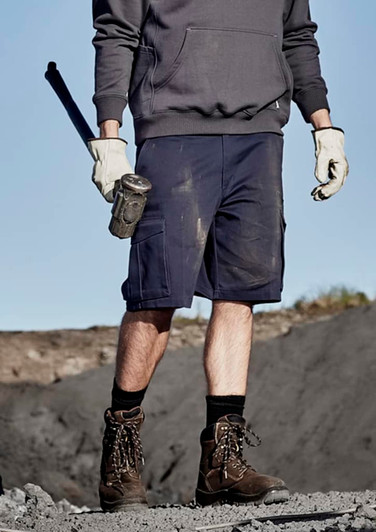 A pair of navy blue men's cargo shorts with multiple pockets, being worn by a person holding a tool.