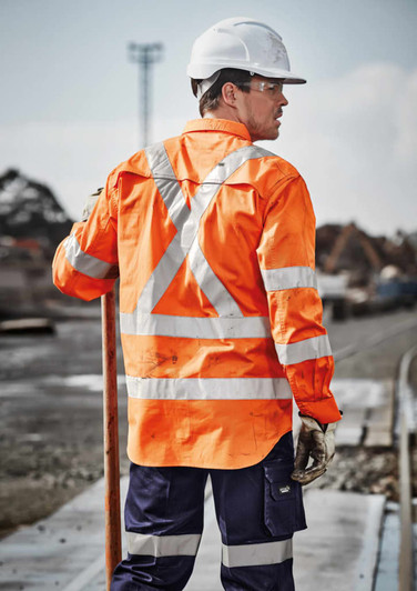 Hi-vis orange long sleeve shirt with reflective tape, worn by a worker on a construction site, featuring a helmet and gloves.