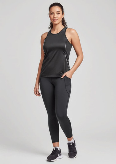 A woman wearing black Luna 7/8 length leggings and a matching tank top, standing confidently with one hand on her hip.