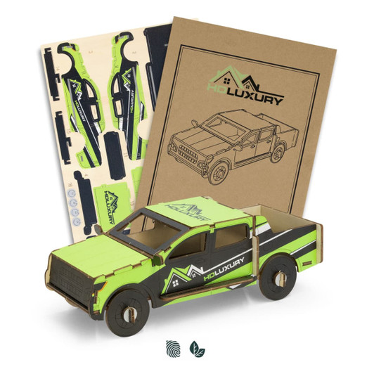 A wooden model of a ute in green and black, accompanied by assembly pieces and packaging.