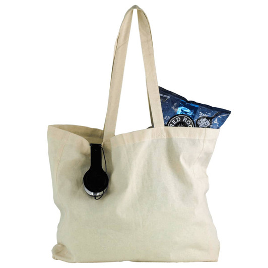 A natural cotton shopper tote in cream, featuring a black headphone and a bag of snacks inside.