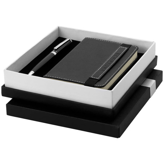 A black notebook and pen set in a sleek black and white gift box. The set features a logo on the notebook.
