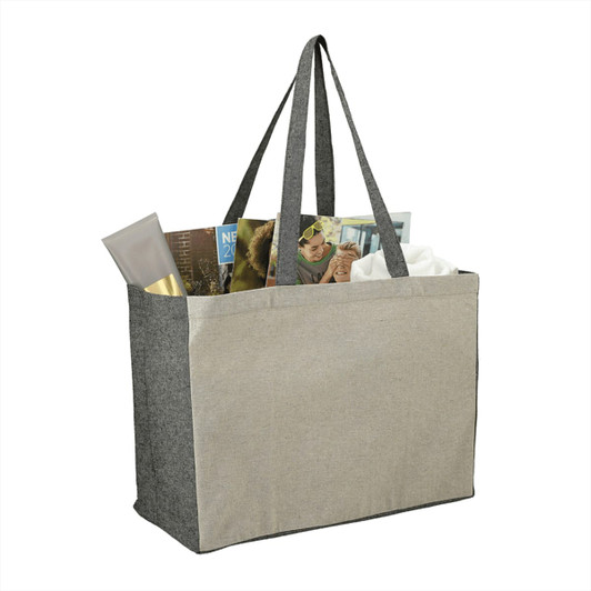 A grey recycled cotton tote bag with long handles, filled with magazines and personal items.