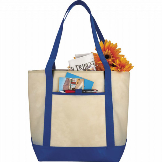 A beige tote bag with blue handles, holding magazines, a notepad, and flowers, featuring a logo.