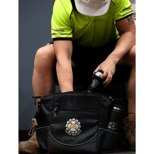 A black bag with a logo, featuring drink bottles and a person wearing a green high-visibility shirt and hard hat.