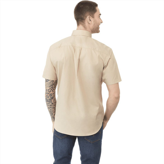 A men's button-up shirt in beige, featuring short sleeves and a back pleat, with a visible logo.